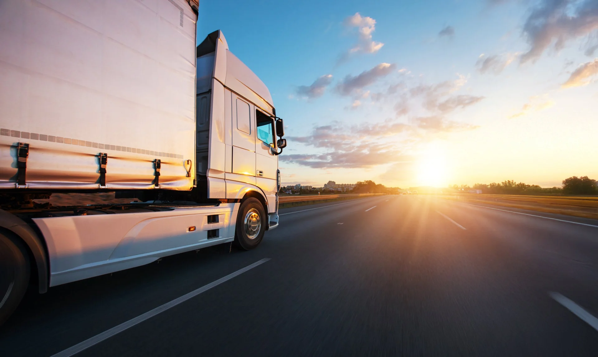 LKW der Mulan Transportation auf der Landstraße in Deutschland bei Sonnenuntergang